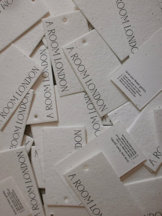 image of aroom london label tag, made of seed paper that is 100% sustainable