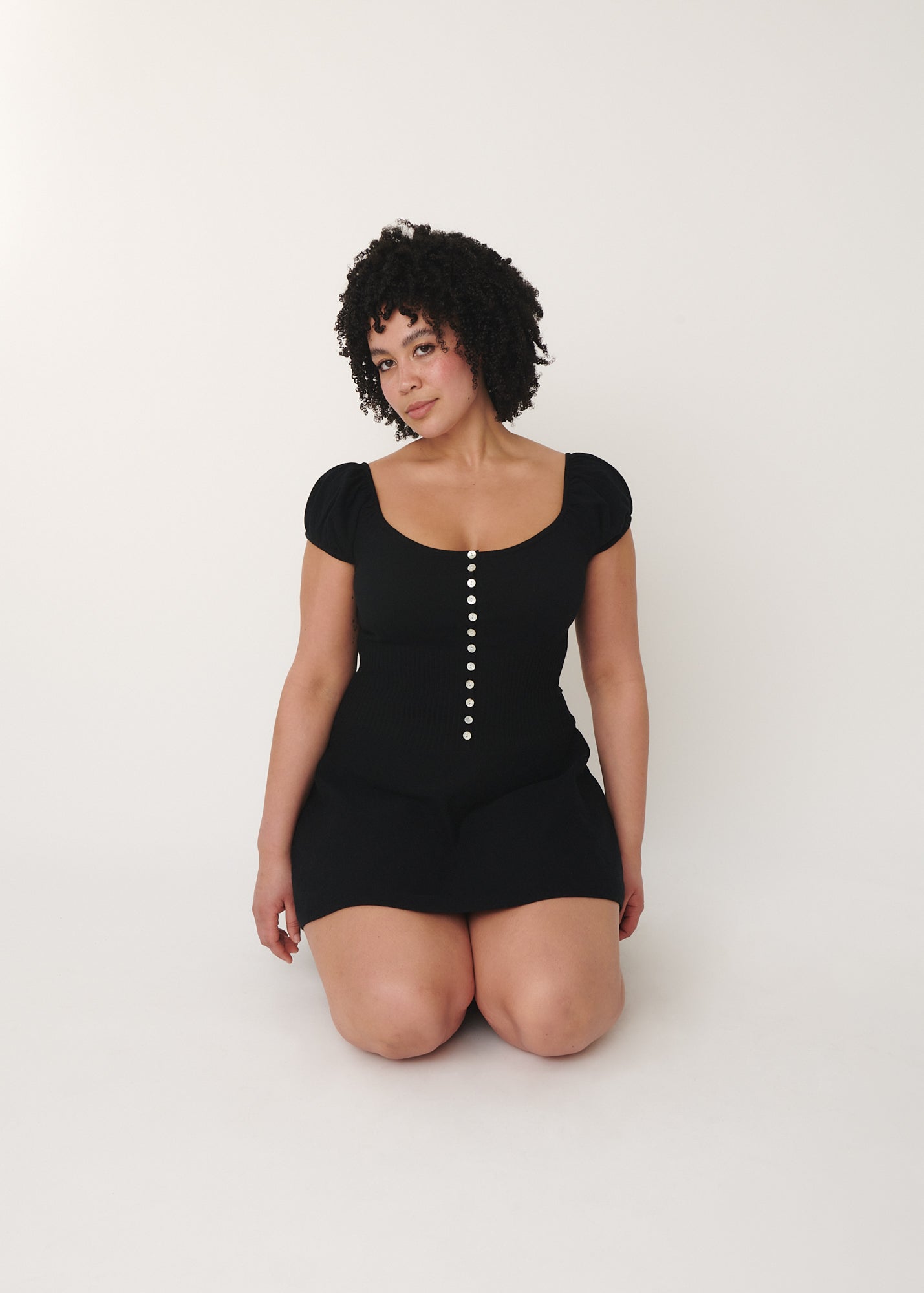 a black model wearing the Lise knitted mini dress designed by A Room London
