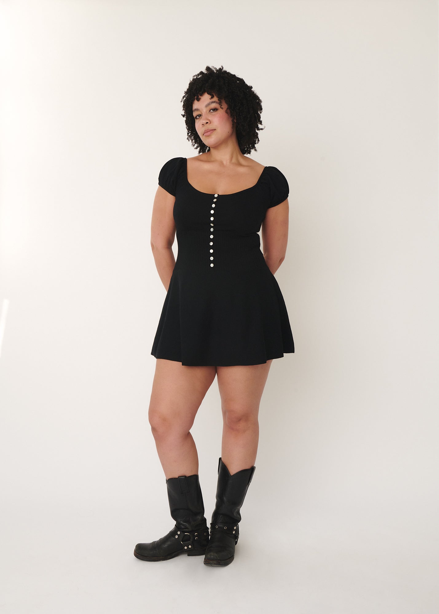 a model wearing lise mini knitted dress in size L, paring with cowboy boots.