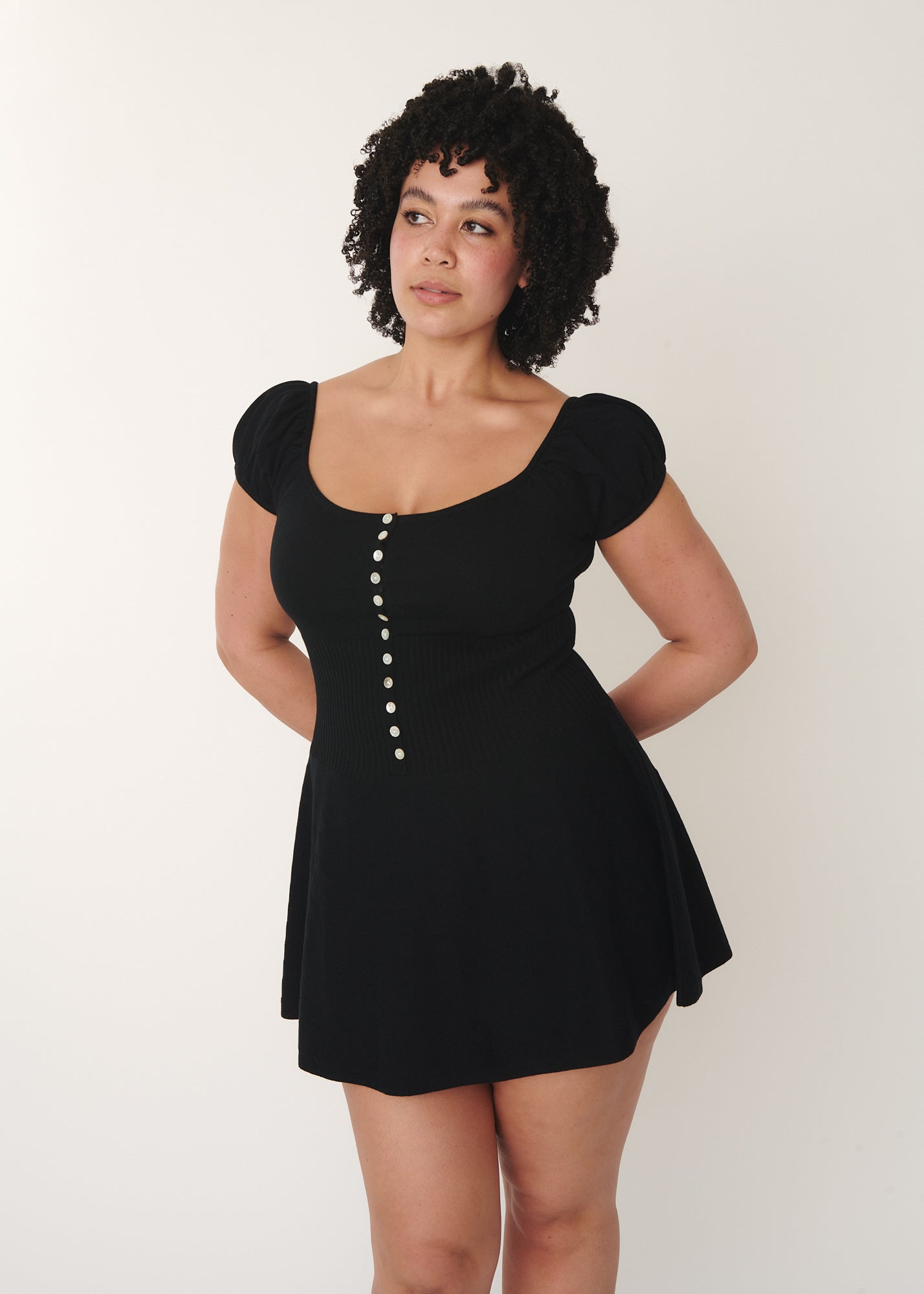 front view of a model wearing Lise dress featuring a mini length and 12 shell buttons, designed by A Room London