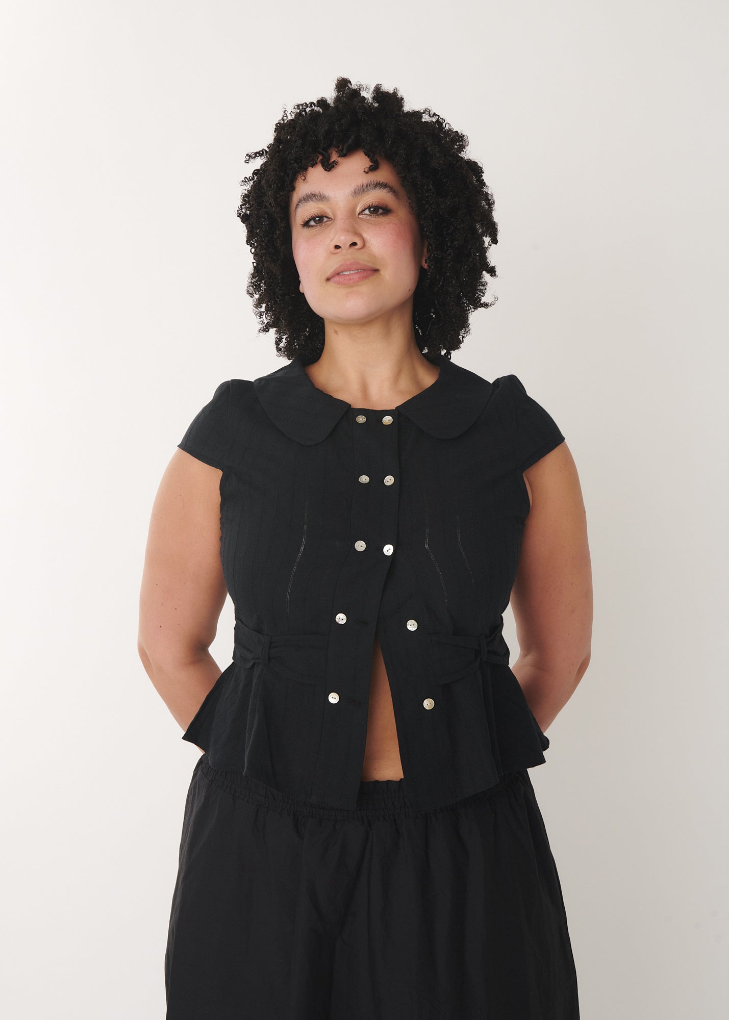 Model wearing the cotton Virginia blouse in black – by A Room London