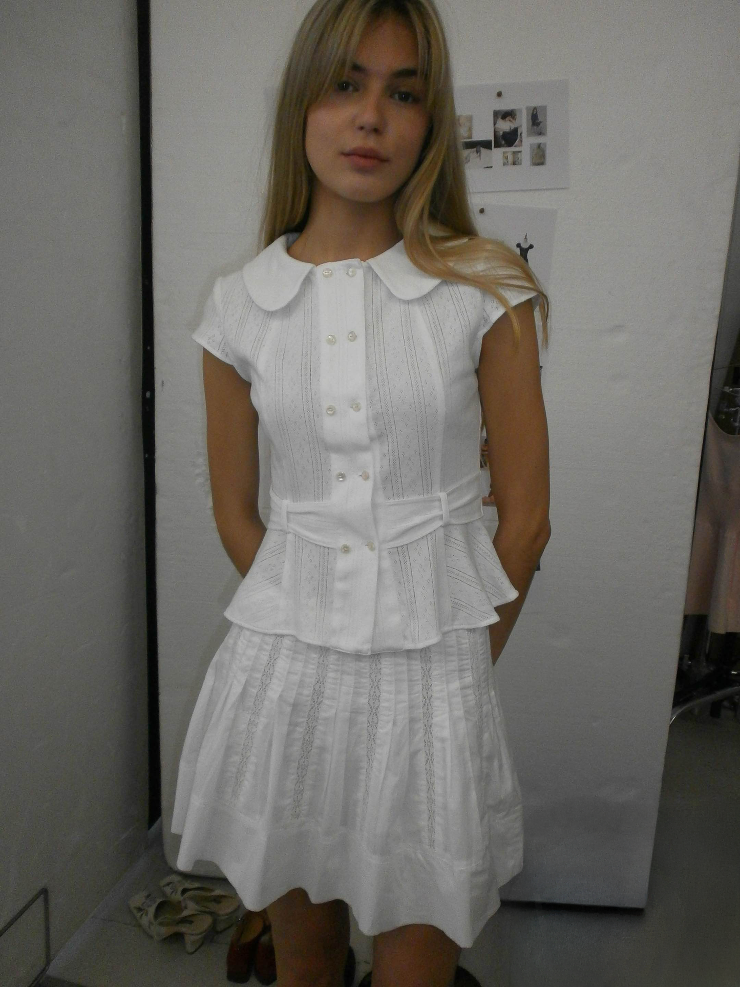 Model wearing the Virginia Blouse Pointelle in white, cute Double breasted shell buttons and cute peter pan collar design cap short sleeve blouse in a indoor setting– independent designer womenswear by A Room London