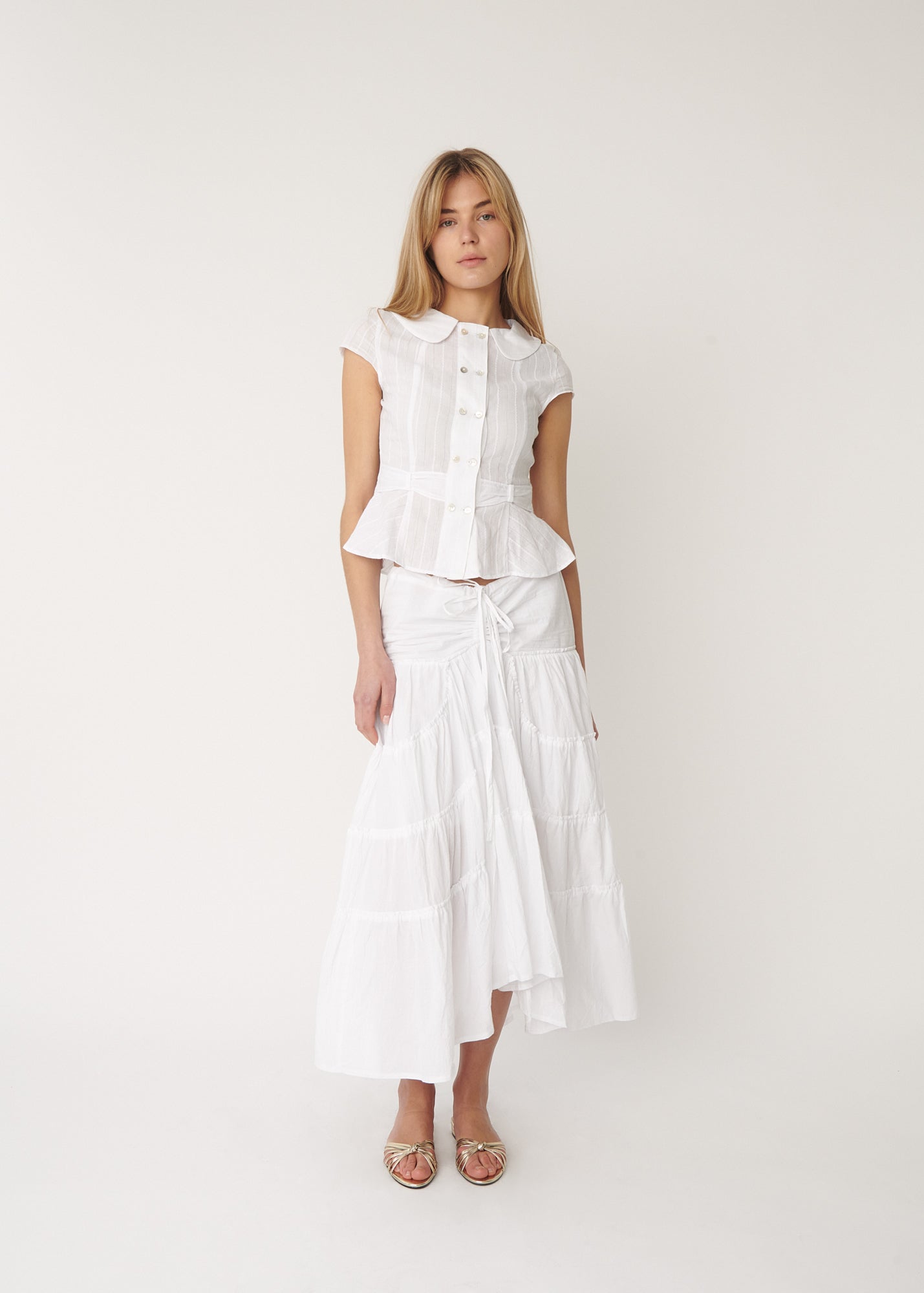 Model wearing the Virginia blouse in white, featuring a tailored waist design– by A Room London