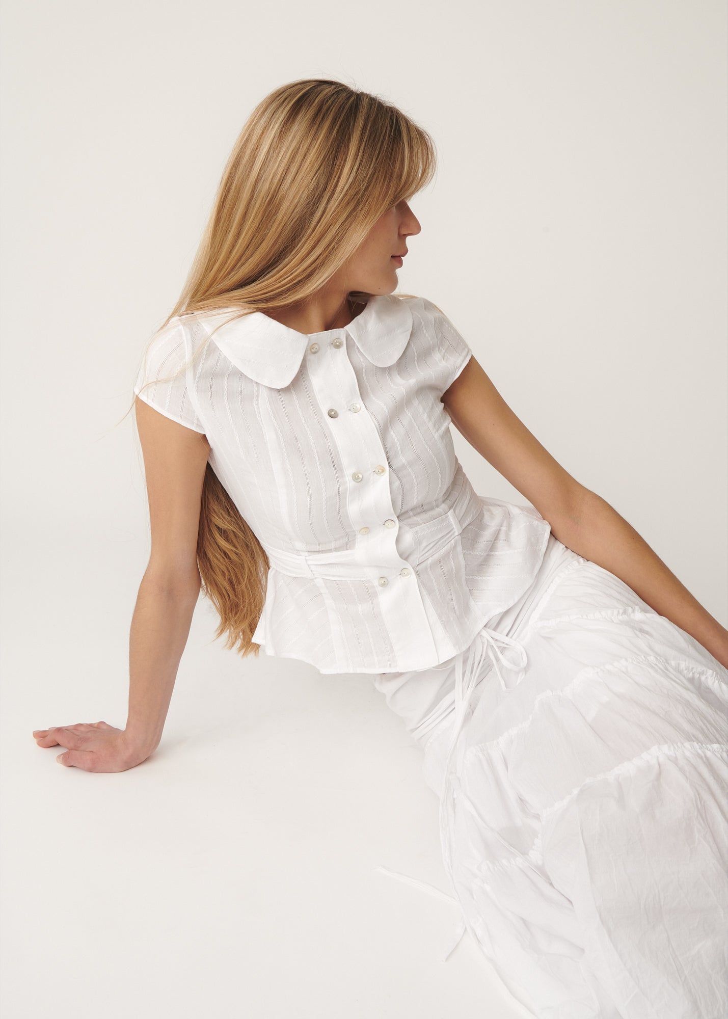 Model wearing the cotton Virginia Blouse in white, showing double-breasted front and Peter Pan collar – A Room London
