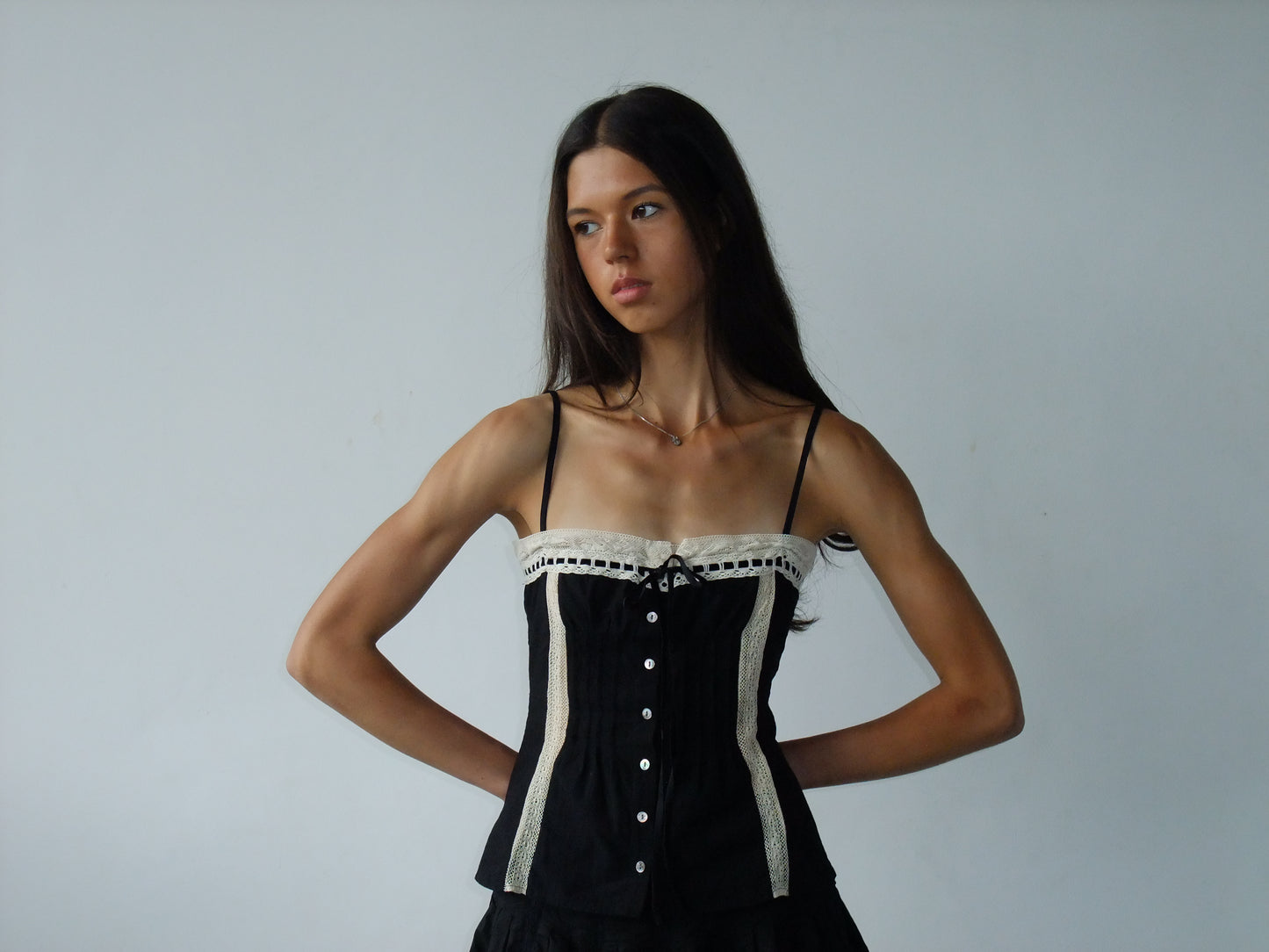 Woman wearing a black cami against a plain background