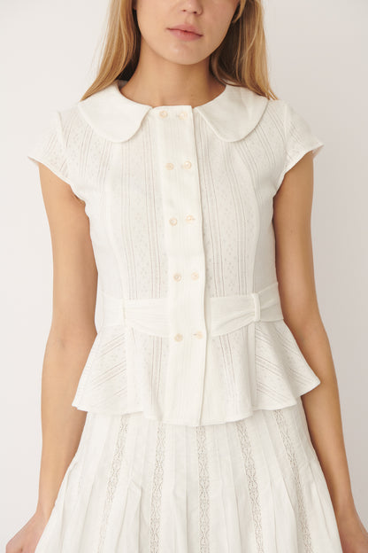 Close-up of buttons or fabric:
Close-up of shell buttons and fine pointelle knit on the Virginia Blouse in white – elegant detailing from A Room London.